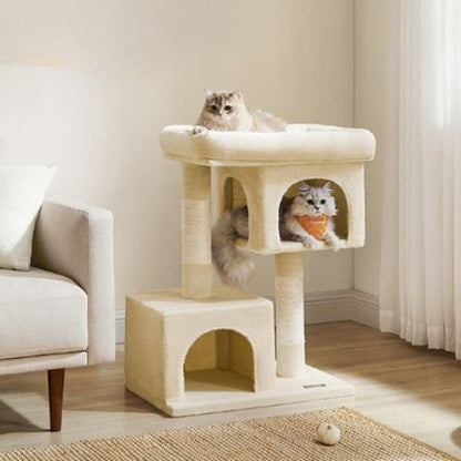 Deux chats jouant et se reposant sur un arbre à chat beige à double niche et grand couchage, installé dans un coin lumineux du salon.