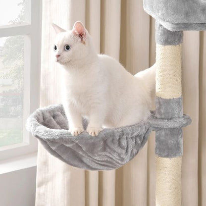  Chat blanc installé dans le hamac d’un arbre à chat gris et poteaux en sisal servant de griffoirs robustes.